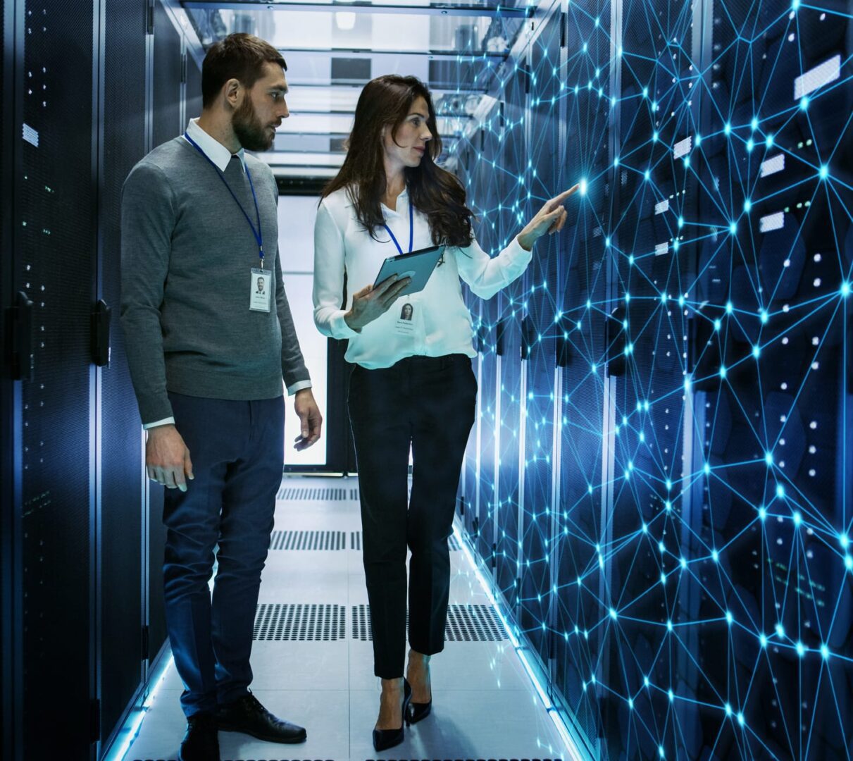Female and Male IT Engineers Discussing Technical Details in a Working Data Center/ Server Room with Internet Connection Visualization.